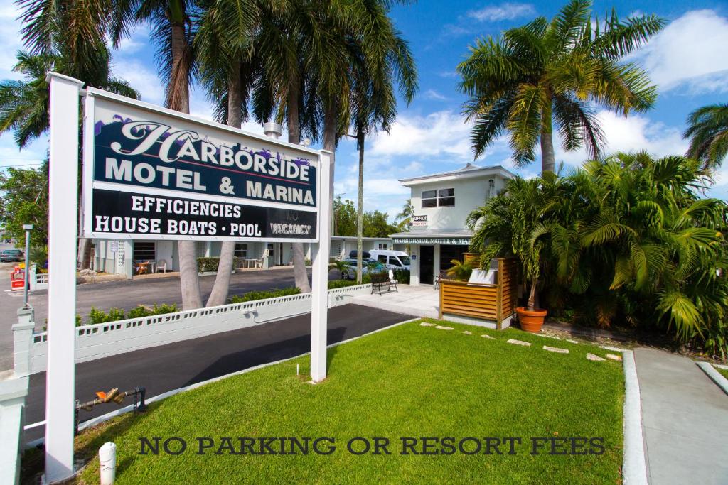una señal de no aparcar ni de las tarifas del complejo frente a una casa en Harborside Motel & Marina, en Key West