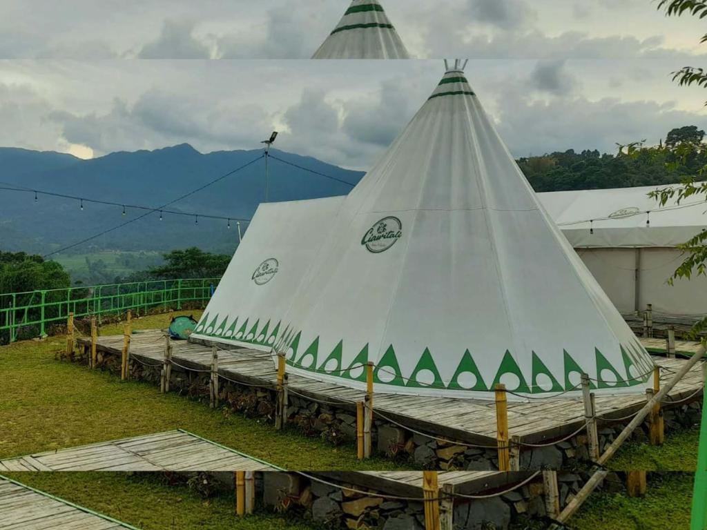 een groep witte tenten met bergen op de achtergrond bij Ciawitali Glamping in Cibitung 2