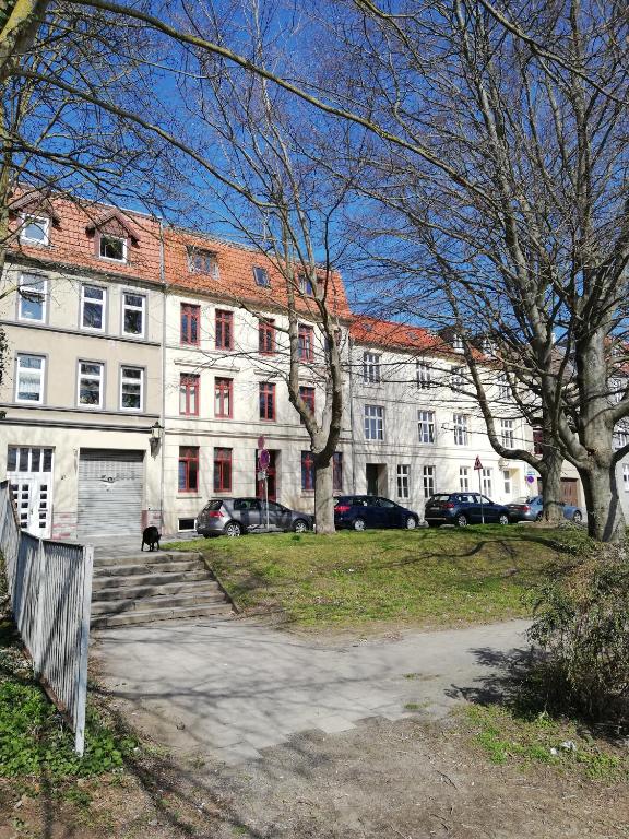 a large white building with cars parked in front of it at Turmstrasse19 in Wismar