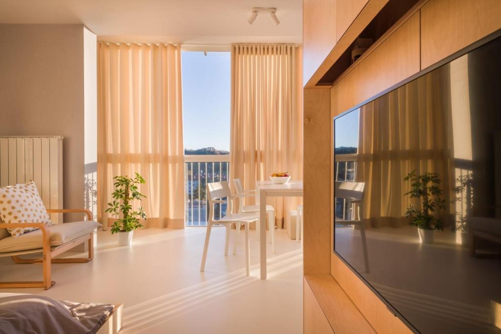 ein Wohnzimmer mit einem Tisch und Blick auf ein Zimmer in der Unterkunft Elegant Studio Apartment with Panoramic View in Nova Gorica