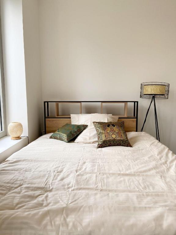 un grand lit blanc avec deux oreillers dessus dans l'établissement Traveller Award 2023, Parc de la Tête d'Or - La Doua - INSA - Université Lyon 1, à Villeurbanne