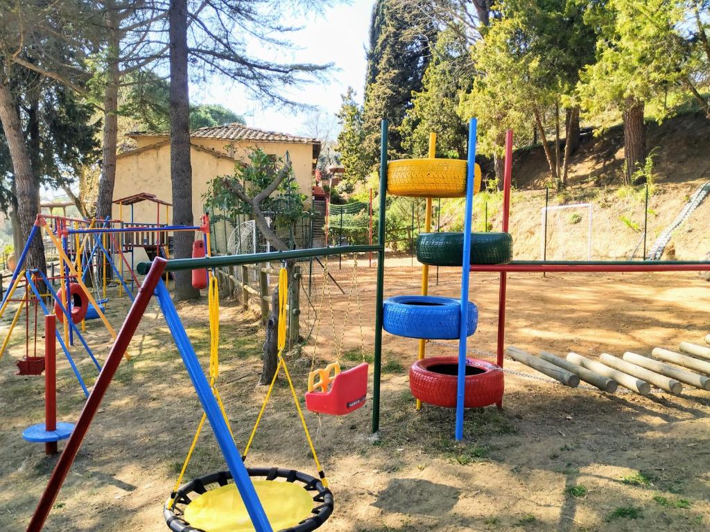 une aire de jeux avec des balançoires de couleur différente et une balançoire dans l'établissement Agriturismo Vernianello, à Poggibonsi