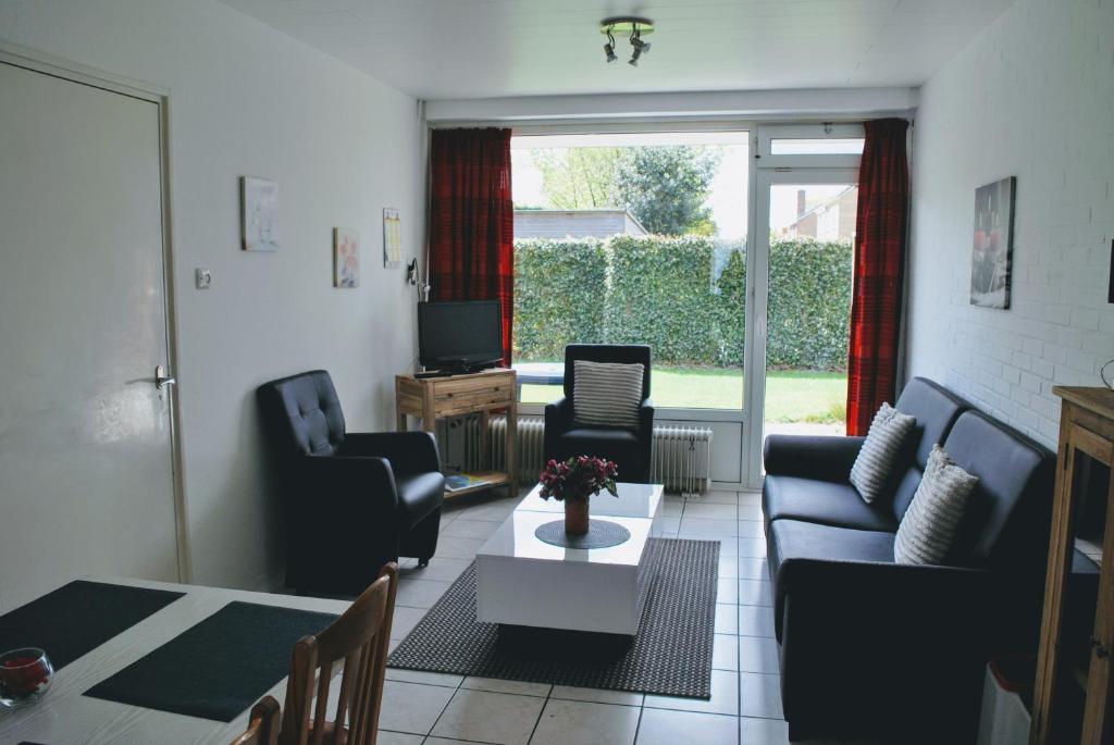 een woonkamer met een bank, stoelen en een tafel bij Appartement Walvis nr. 16 in Vrouwenpolder