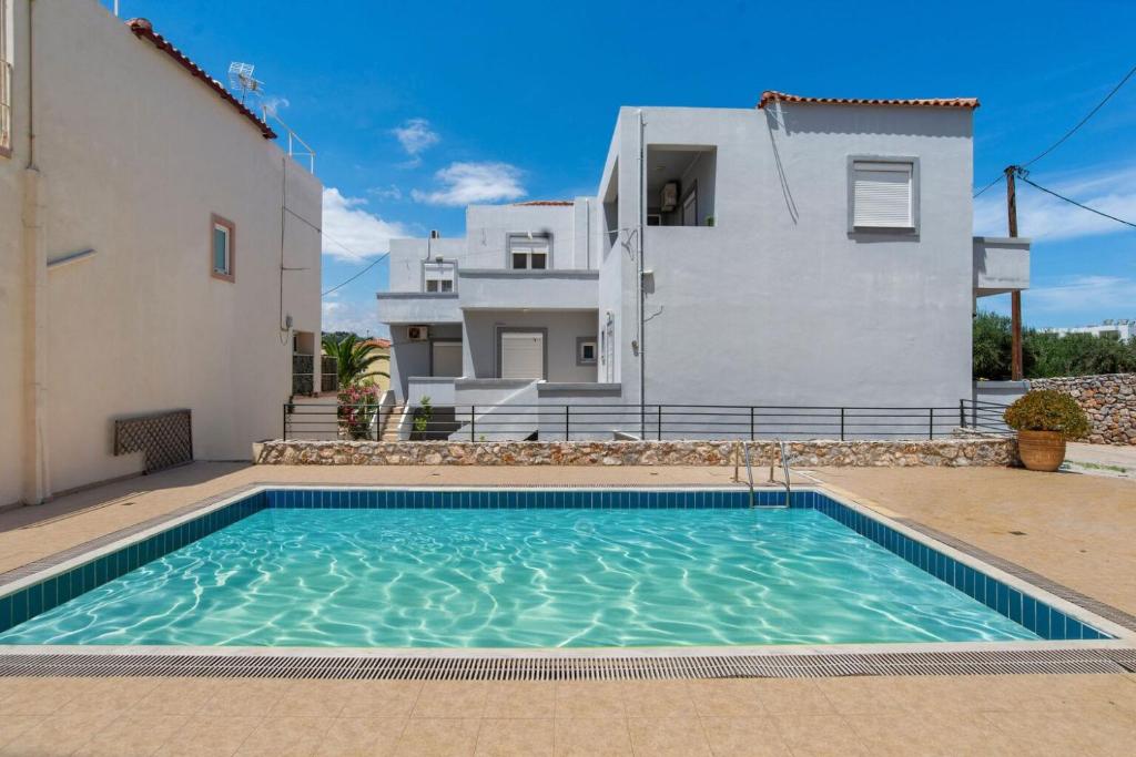 eine Villa mit einem Pool vor einem Haus in der Unterkunft Almyrida milly's apartment I in Chania