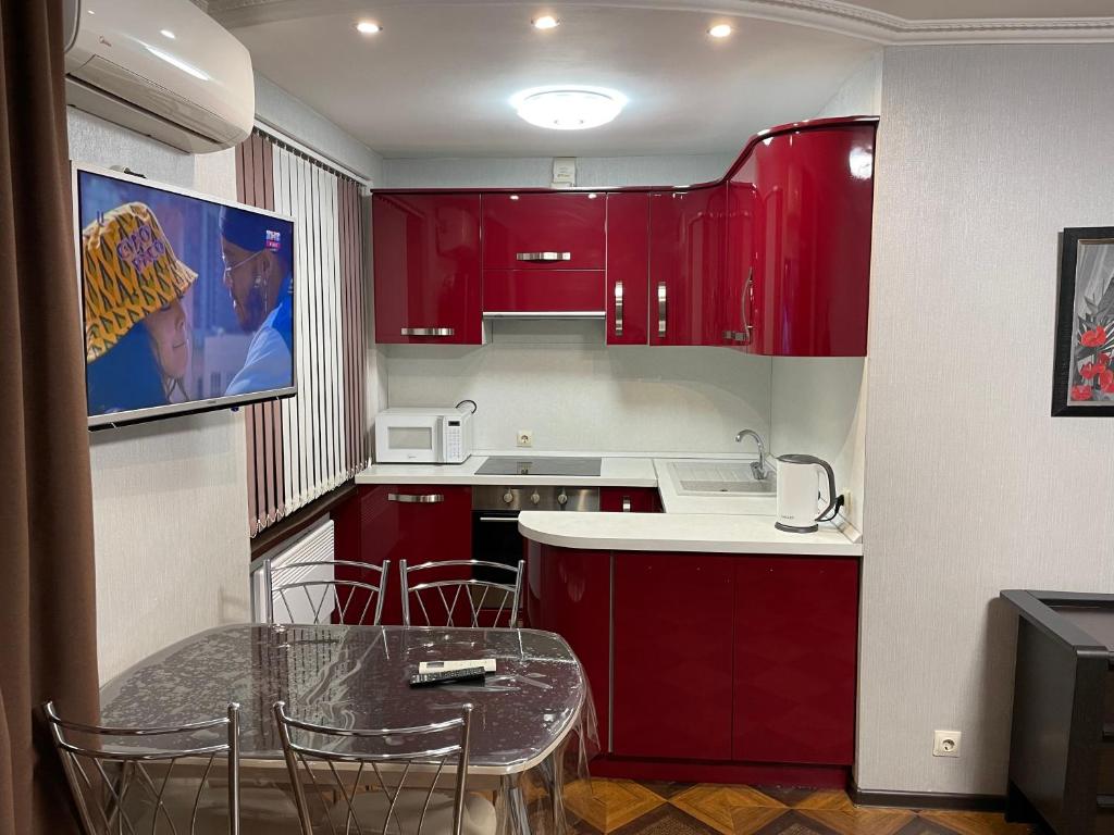 a kitchen with red cabinets and a table with chairs at Studio at Vardaniya 7 in Sukhum