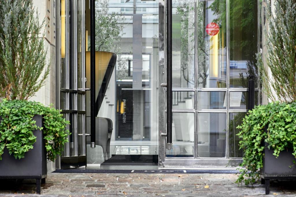 a glass door of a building with two potted plants at H15 Boutique Hotel, Warsaw, a Member of Design Hotels in Warsaw