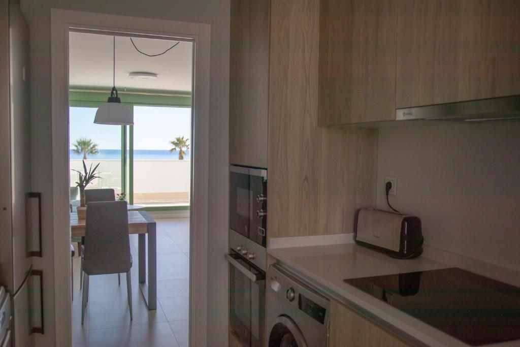 A kitchen or kitchenette at Precioso apartamento frente a la playa con piscina