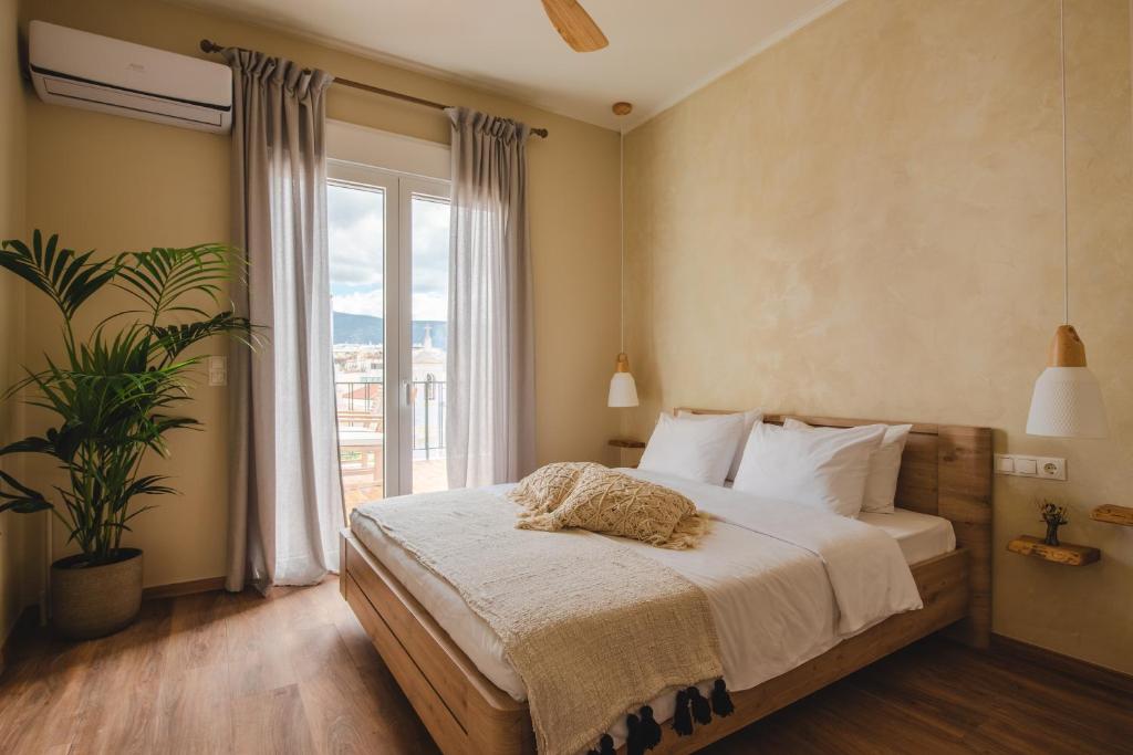 una camera con un grande letto e una grande finestra di Living Stone Aparthotel ad Atene