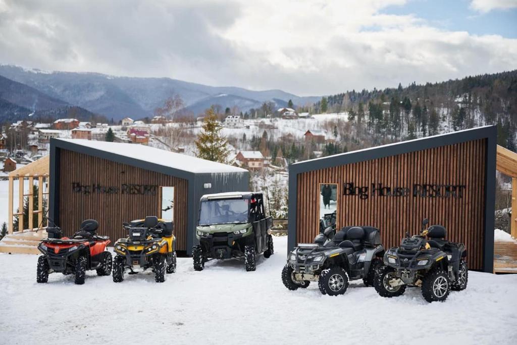 four atvs parked in the snow next to a building at Blog House Resort in Yaremche