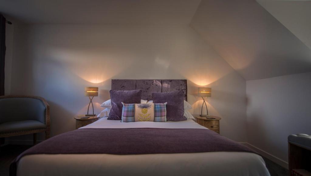 a bedroom with a large bed with purple pillows at Craigmonie Bed & Breakfast in Drumnadrochit