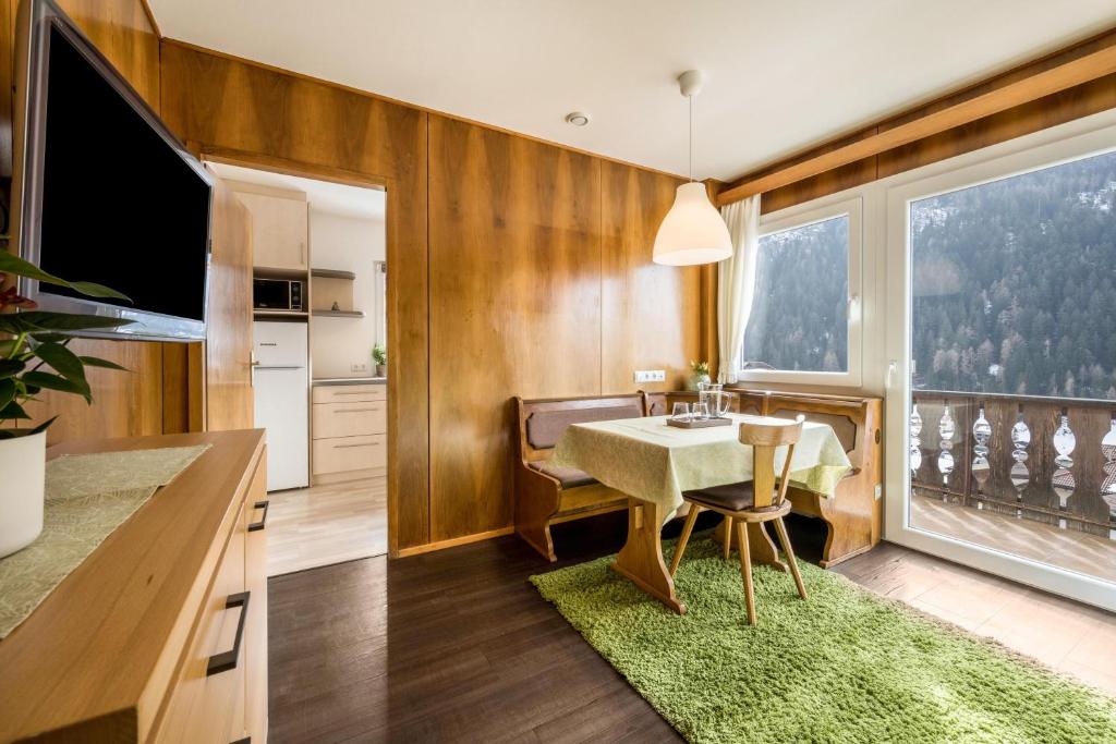 a dining room with a table and a large window at Apartment Sciadules in Ortisei