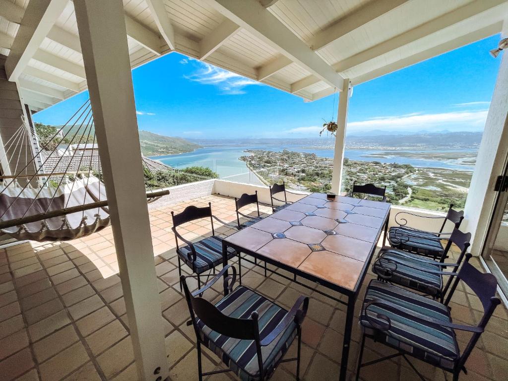 a patio with a table and chairs on a balcony at The White House in Knysna