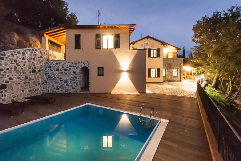 a villa with a swimming pool in front of a house at Agriturismo Le Meridiane in Borgomaro