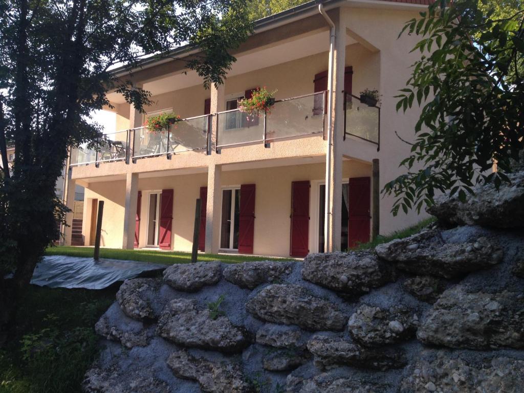 a house with a stone wall in front of it at Le Mas de Servant Roulottes et chambres d'hôtes in Auberives-en-Royans