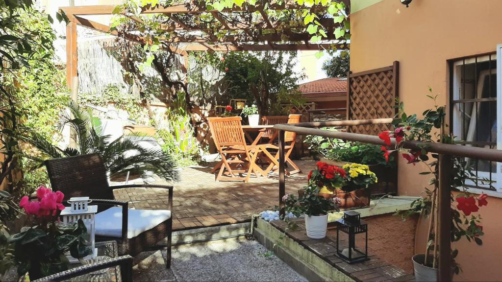 een patio met een tafel, stoelen en bloemen bij Casa Federico - beauty apartment with wonderful terrace in Rome