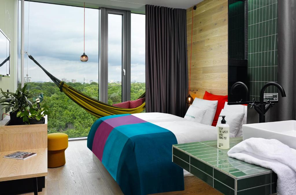 a bedroom with a hammock and a bed with a view at 25hours Hotel Bikini Berlin in Berlin