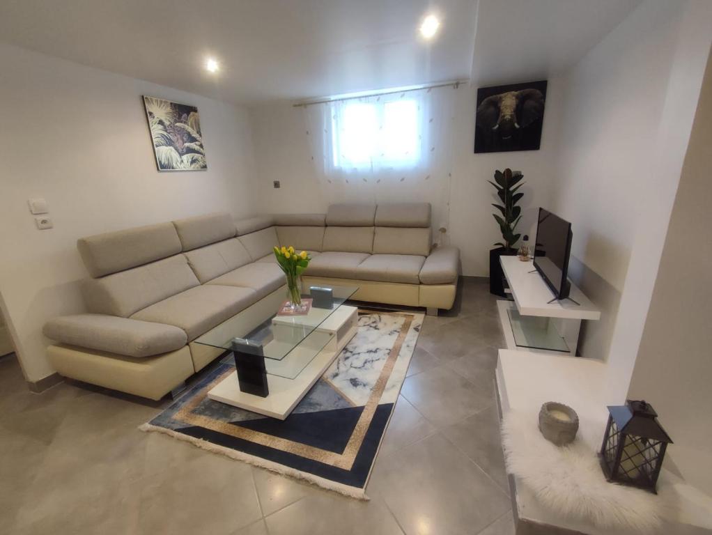 un soggiorno con divano e tavolo di Appartement 100m2, indépendant dans notre maison a Garennes-sur-Eure