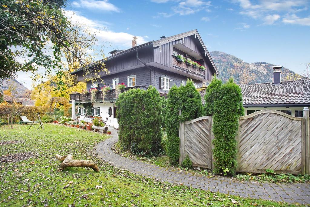 a house with a fence and a dog in the yard at Voglsang - Haus Annamirl in Bayrischzell