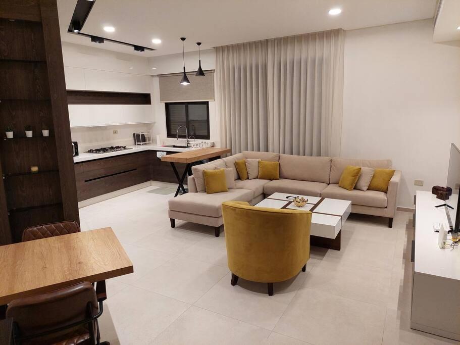 a living room with a couch and a table at Exquisite Modern 2-bedroom Rental Unit in Amman