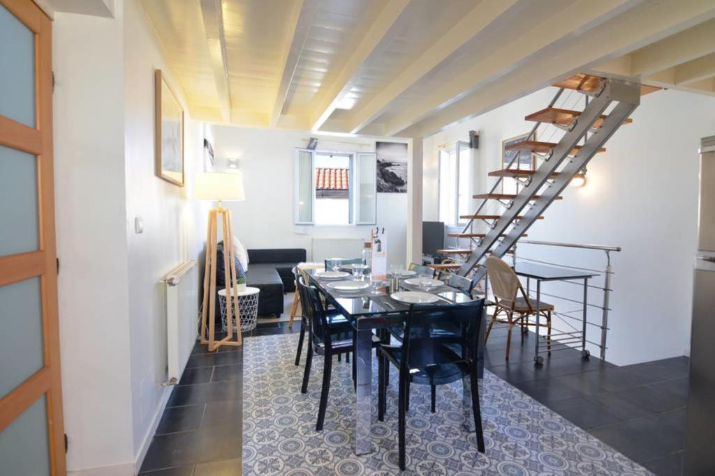 une salle à manger avec une table et des chaises noires dans l'établissement Duplex Voltaire Modern Apartment - 3 bedrooms - citycenter and beach - WIFI, à Biarritz