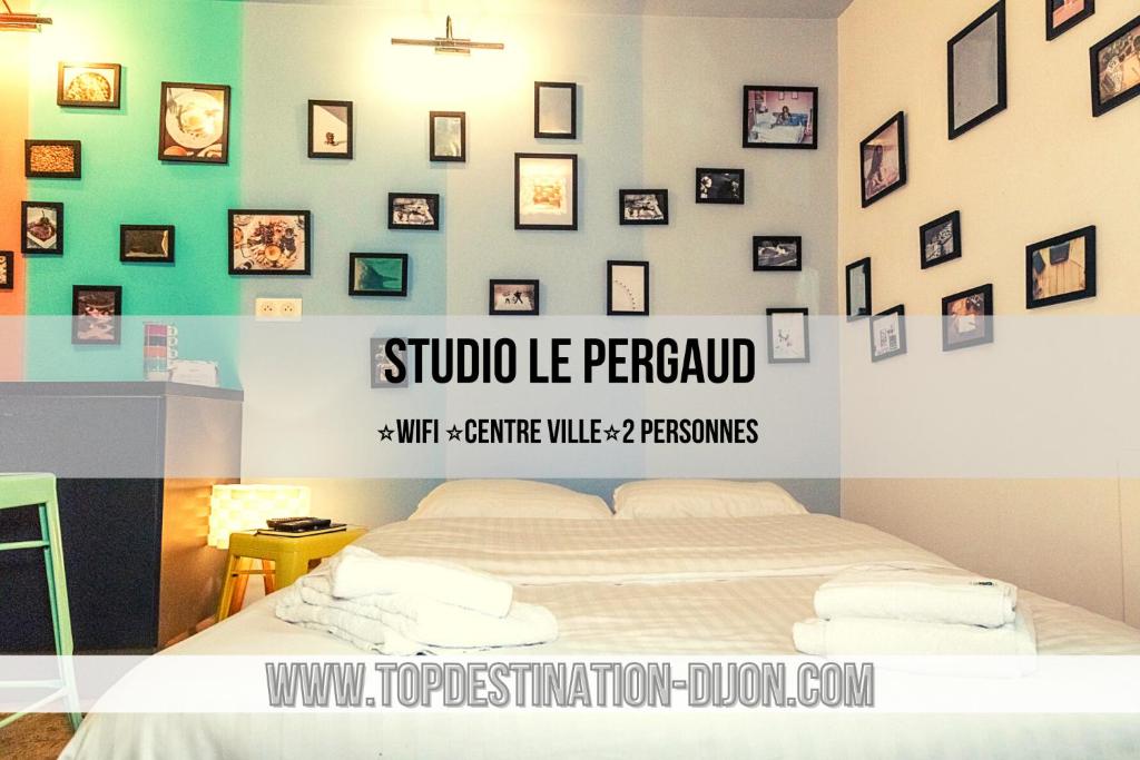ディジョンにあるSTUDIO LE PERGAUD Topdestination-Dijon - Centre ville - Classé 2 étoilesのベッドルーム1室(ベッド1台付)が備わります。壁には絵画が飾られています。