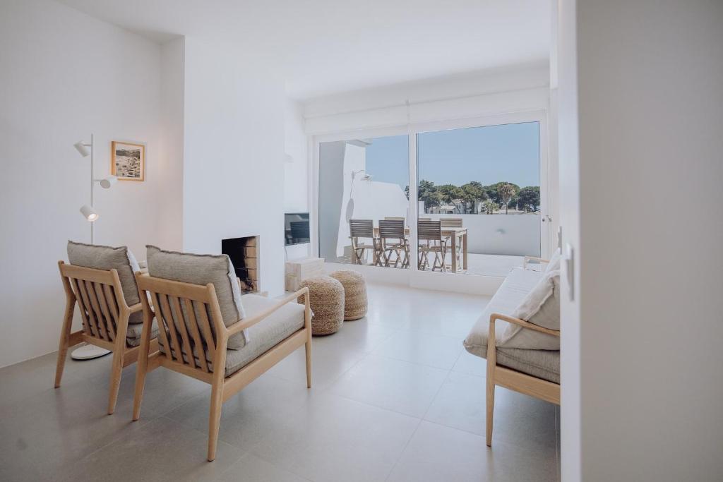 a living room with chairs and a fireplace at Casa Balaia 70 in Albufeira