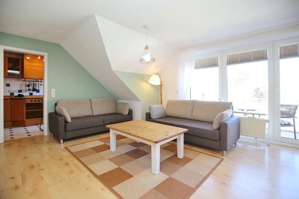 a living room with two couches and a table at Am Mariannenweg Wohnung 11 in Boltenhagen