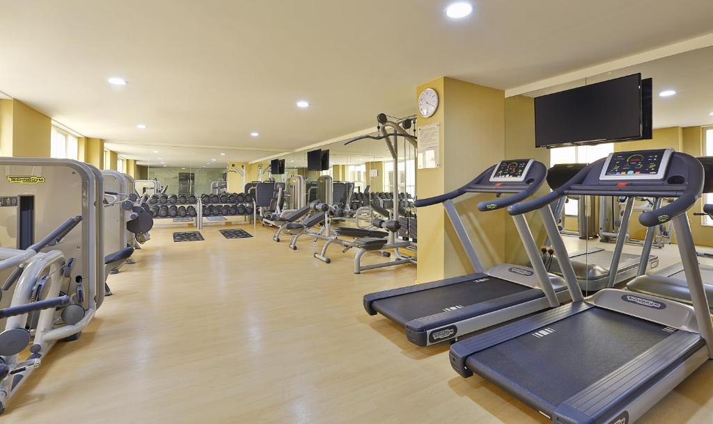 a gym with several tread machines and a flat screen tv at Gateway Hotel in Dubai
