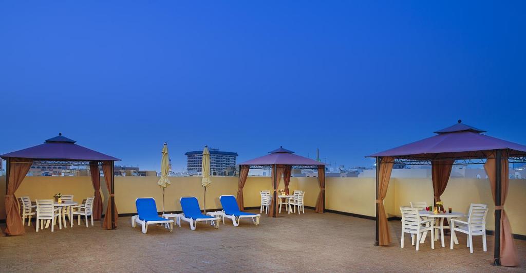 a patio with chairs and tables and gazebos at Gateway Hotel in Dubai