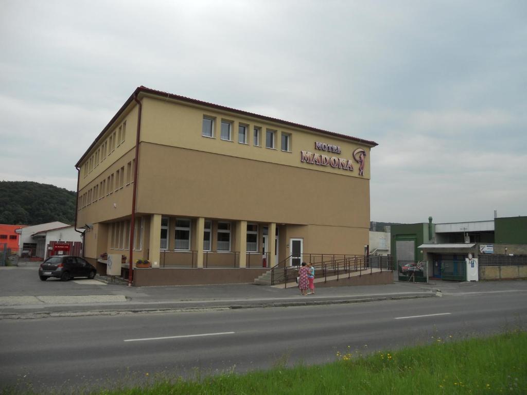 una mujer parada frente a un edificio en Motel Madona en Banská Bystrica