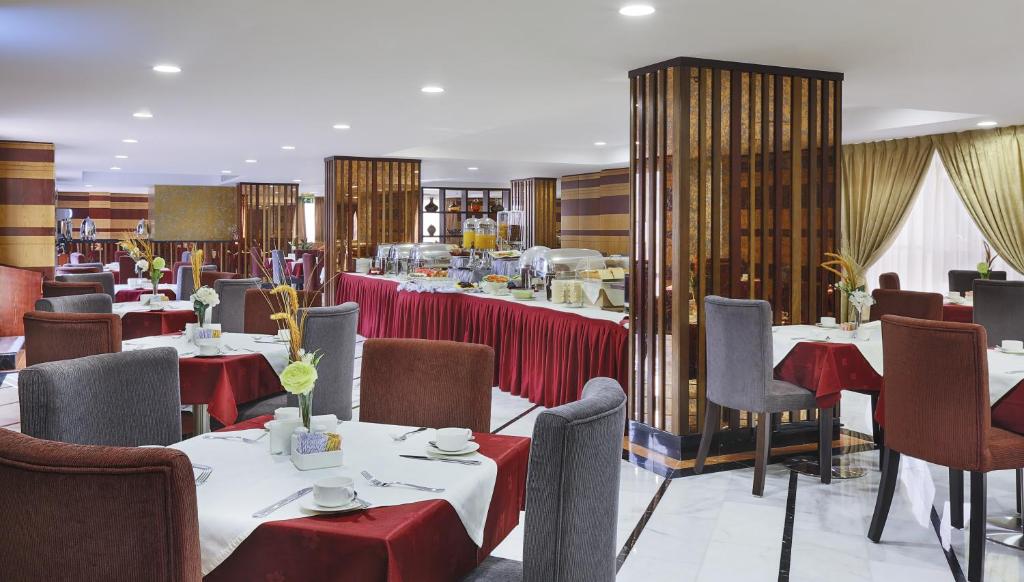 a restaurant with tables and chairs in a room at Gateway Hotel in Dubai