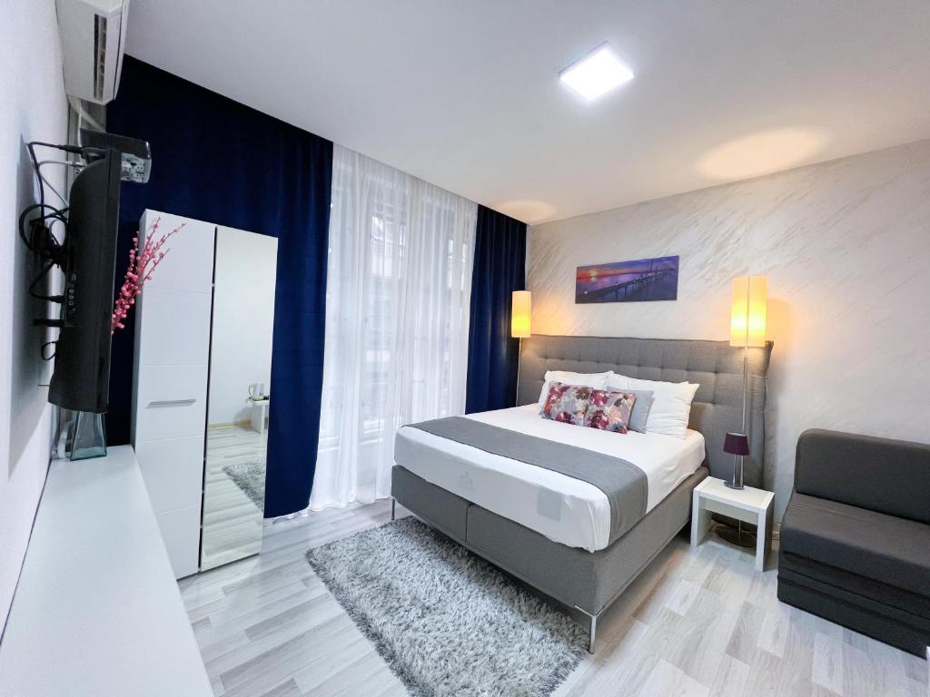 a bedroom with a bed and a chair and a mirror at Centar Forever in Belgrade
