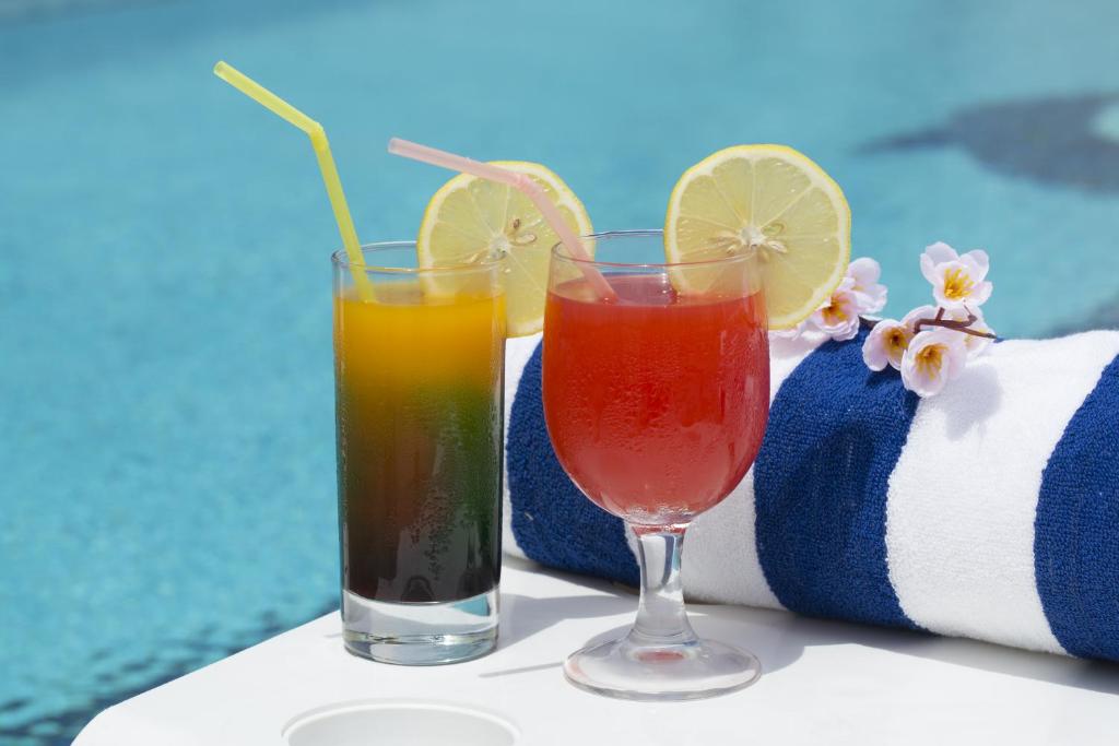 two cocktails in glasses sitting on a table with towels at Gateway Hotel in Dubai