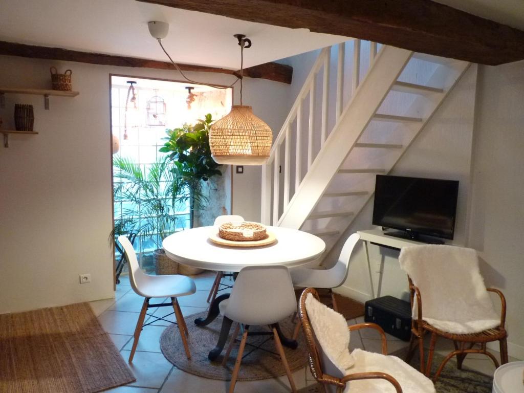 una sala da pranzo con tavolo e sedie bianchi di La petite maison CARRÉ a Talant