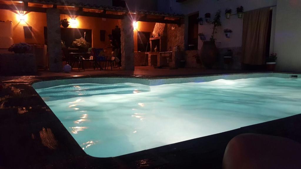 - une grande piscine d'eau bleue la nuit dans l'établissement Casa Rural la Abuela Amelia, à Garcinarro