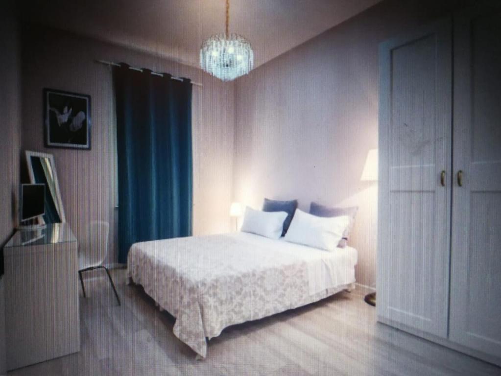 een slaapkamer met een wit bed en een kroonluchter bij Central 2 bedrooms 2 bathrooms in Ancona