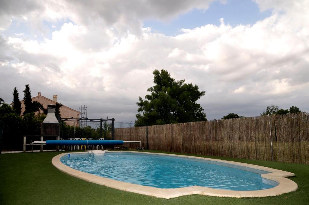 una piscina en un patio con una valla de madera en La Fresneda de Polendos, en Cabañas de Polendos