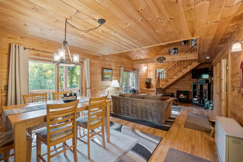 a dining room and living room with a wooden ceiling at Log Home Retreat at Lake Winnipesaukee! in Meredith