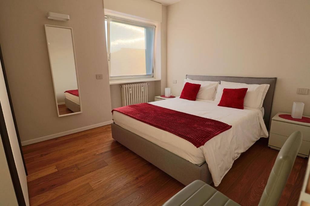 1 dormitorio con cama con almohadas rojas y espejo en Aparthotel Isola, en Milán