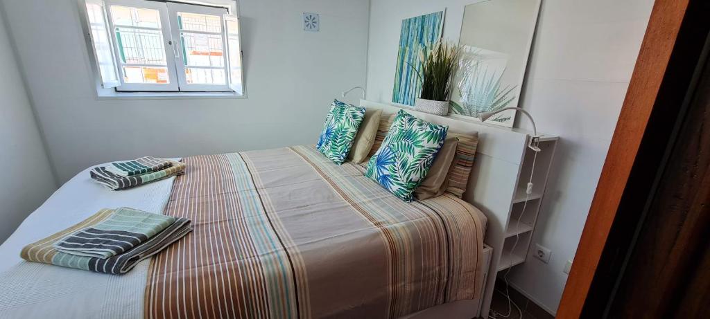 una cama con almohadas en una habitación en Cantinho Saloio, en Sintra