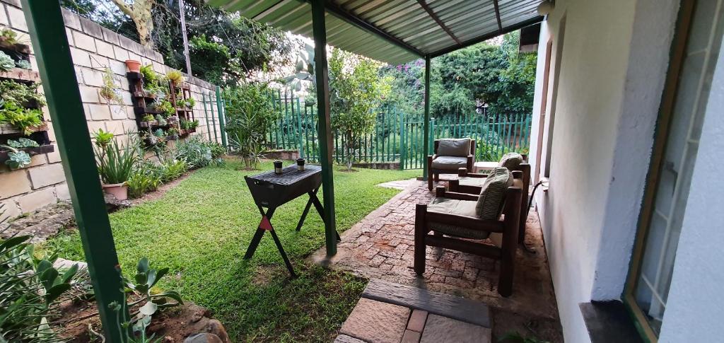 a patio with two chairs and a grill in a yard at Sister's Haven in Nelspruit