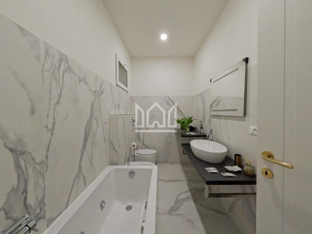 łazienka z wanną, toaletą i umywalką w obiekcie Gold River House w mieście Ferrara