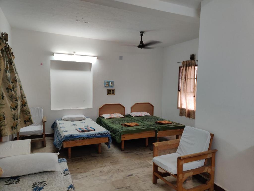 Zimmer mit 2 Betten, einem Tisch und Stühlen in der Unterkunft Daya Dharma residency in Tiruvannāmalai