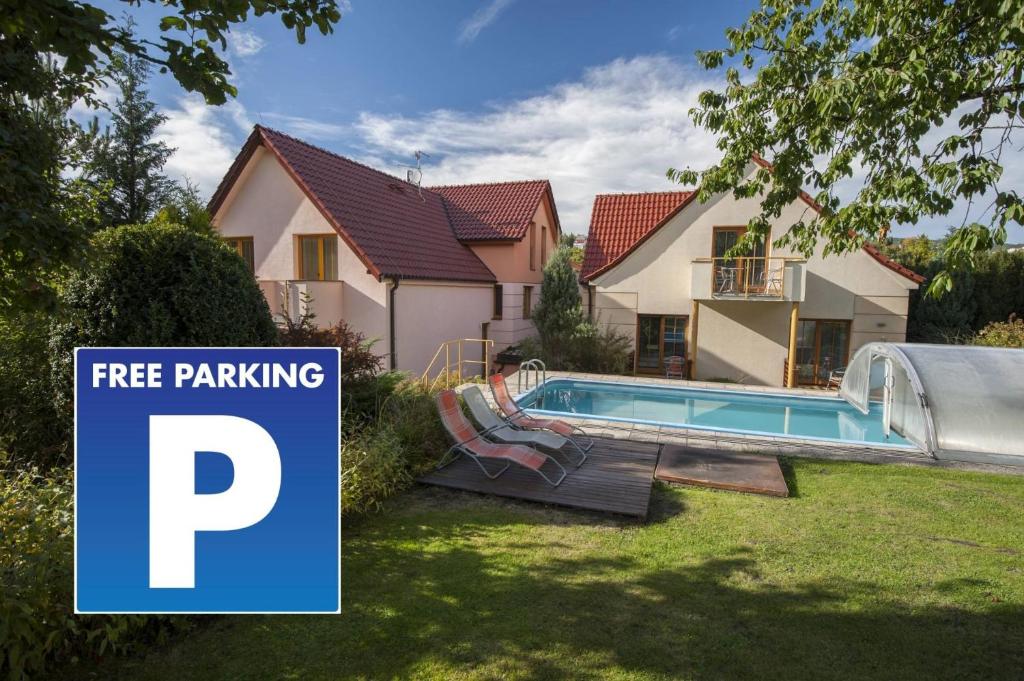 a house with a free parking sign next to a swimming pool at Hotel Garni Pod Skalkou in Český Krumlov