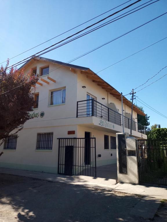 uma casa branca com uma cerca à frente. em LOS CEDROS em Junín de los Andes