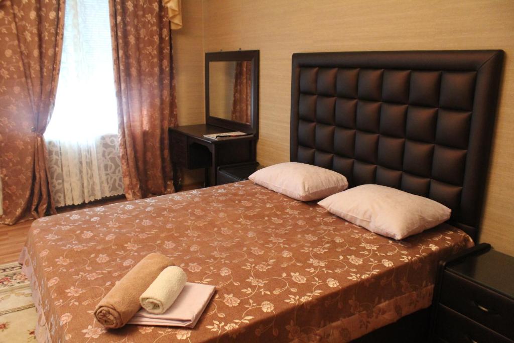 a bedroom with a bed with two towels on it at Petrovsk Hotel in Makhachkala