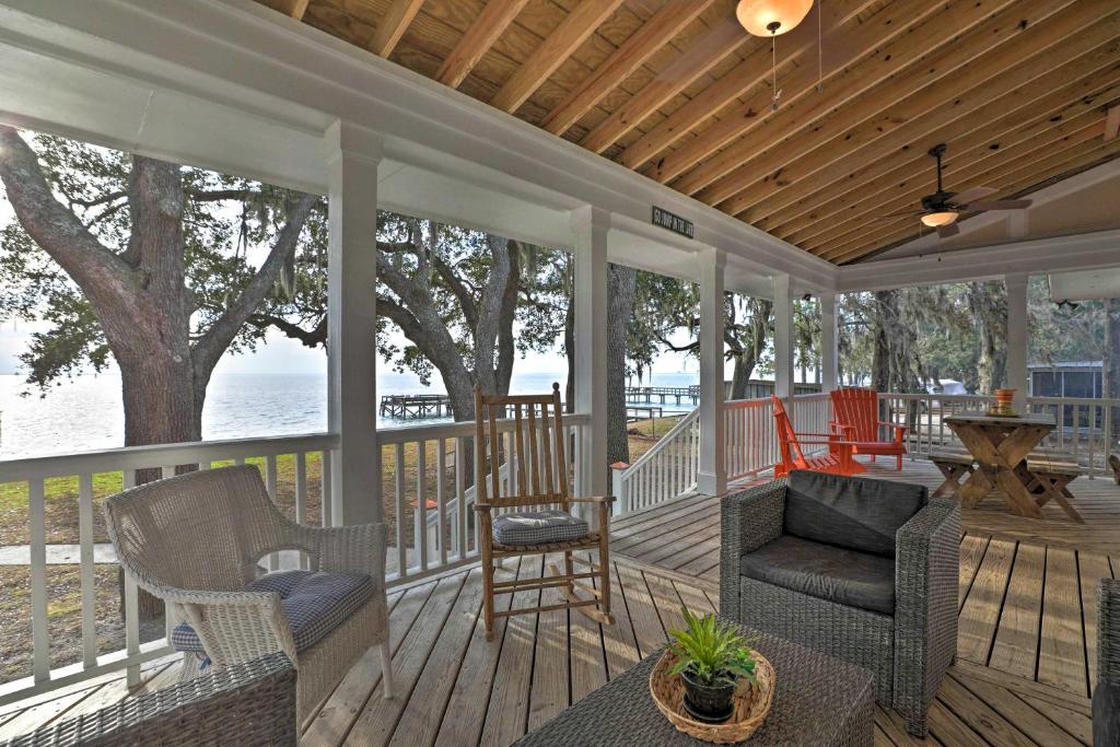 un porche cubierto con sillas y mesa en Lakefront Retreat with Game Room and Private Dock!, en Bonneau