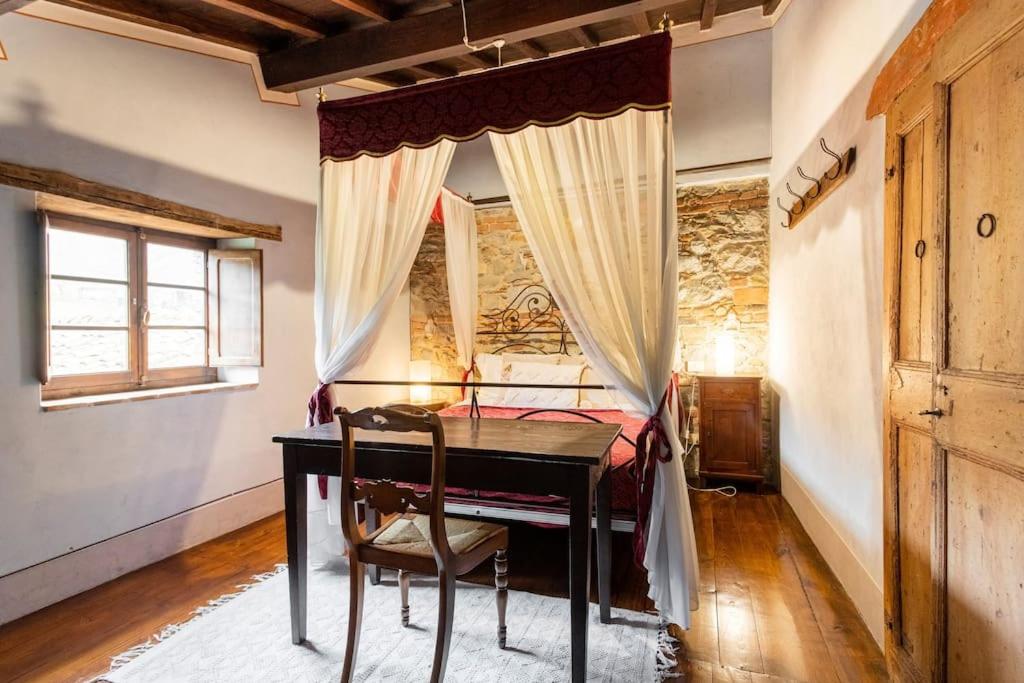 a bedroom with a desk and a bed with a window at Sambuca Home Loft in San Romano in Garfagnana