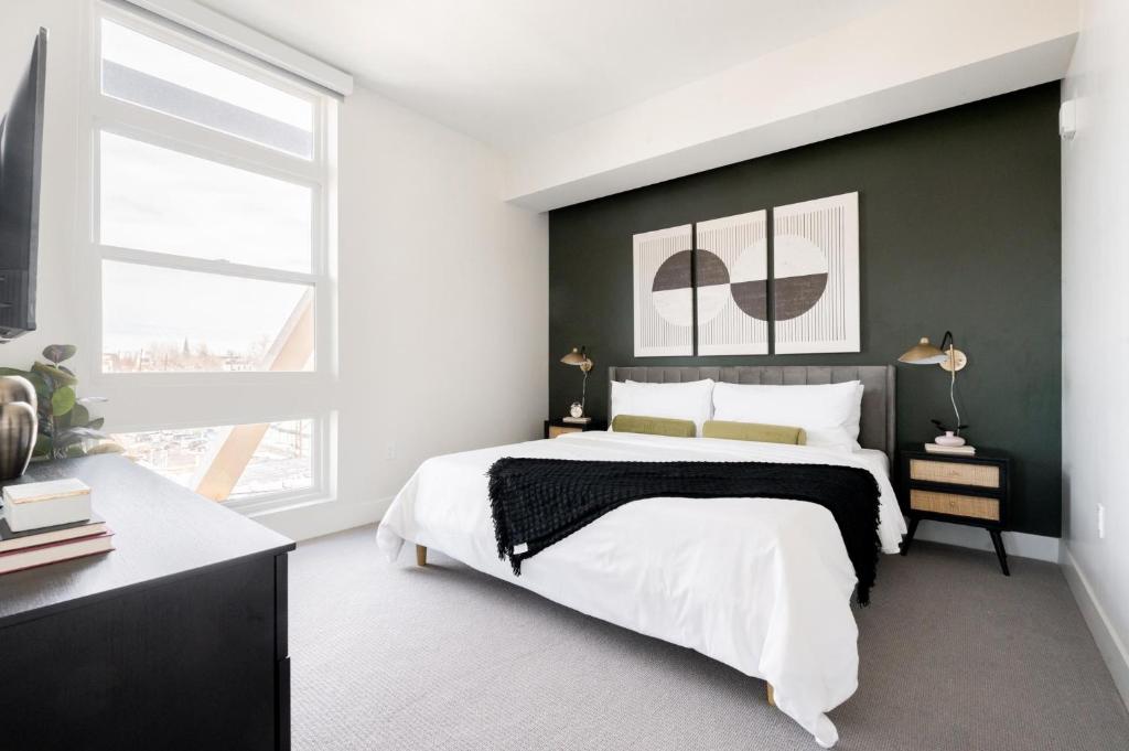 1 dormitorio con 1 cama grande y pared negra en Chic Gallery Loft - Amazing Deck - Zuni Lofts en Denver