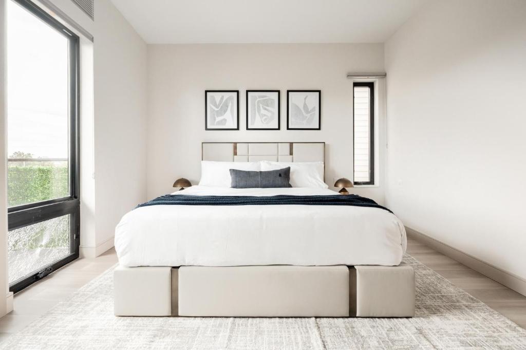 a white bedroom with a large bed and large windows at Contemporary Condo - Grill - Balcony - Tesoro in Denver